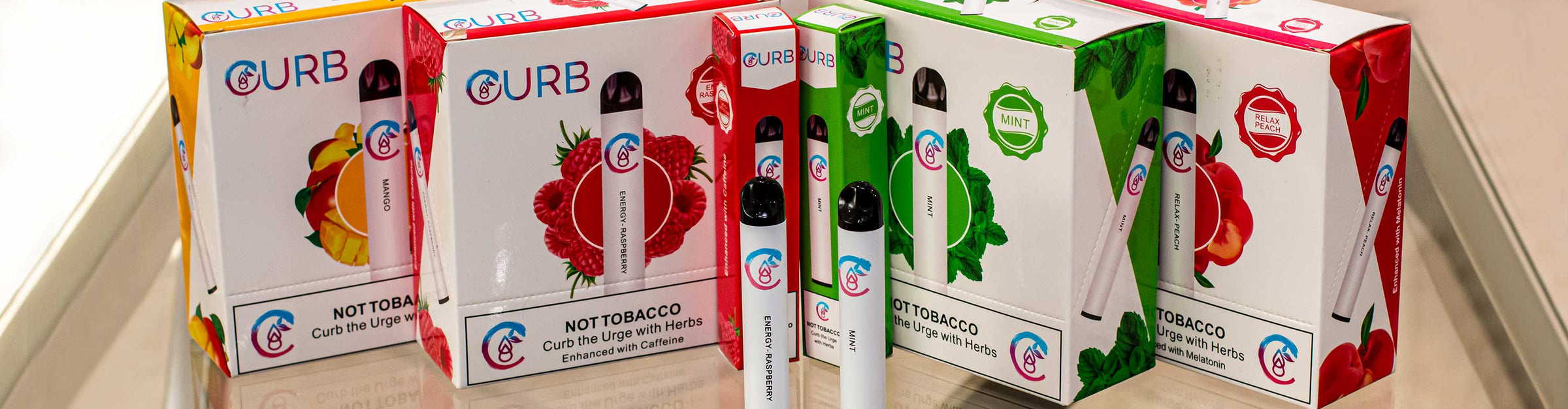 Wholesale Curb herbal disposable vaporizers with packaging standing on glass table